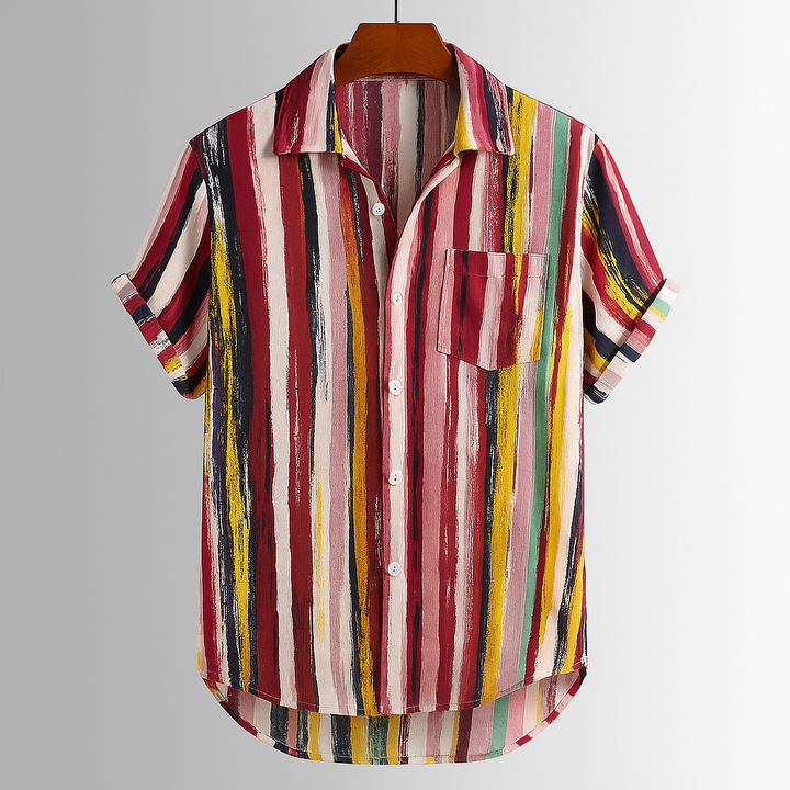 Close-up of a men's abstract artisan print shirt, showing vibrant colors and relaxed short sleeves.