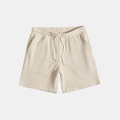 Man relaxing in a comfortable men's Algarve waffle loungewear set, perfect for casual home wear.
