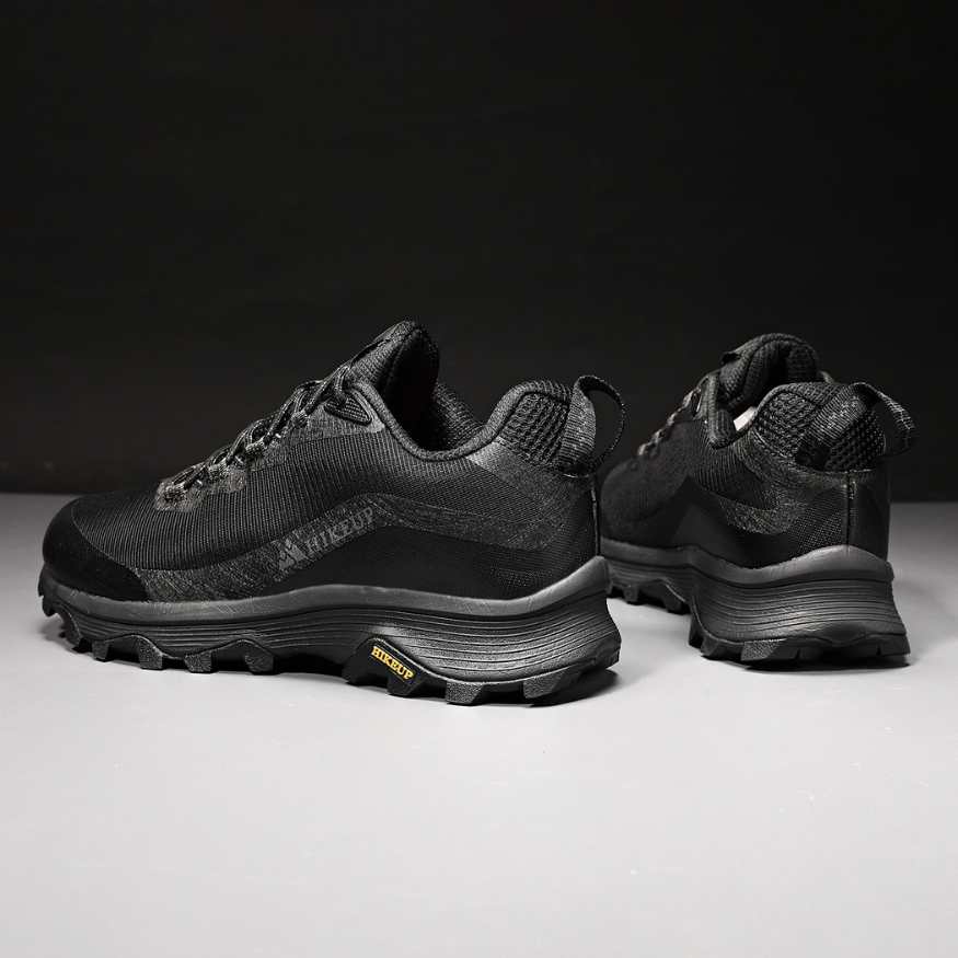 Close-up of men's durable outdoor boots, showcasing rugged soles for superior hiking traction.