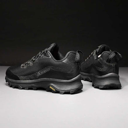 Close-up of men's durable outdoor boots, showcasing rugged soles for superior hiking traction.