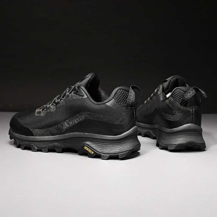 Close-up of men's durable outdoor boots, showcasing rugged soles for superior hiking traction.