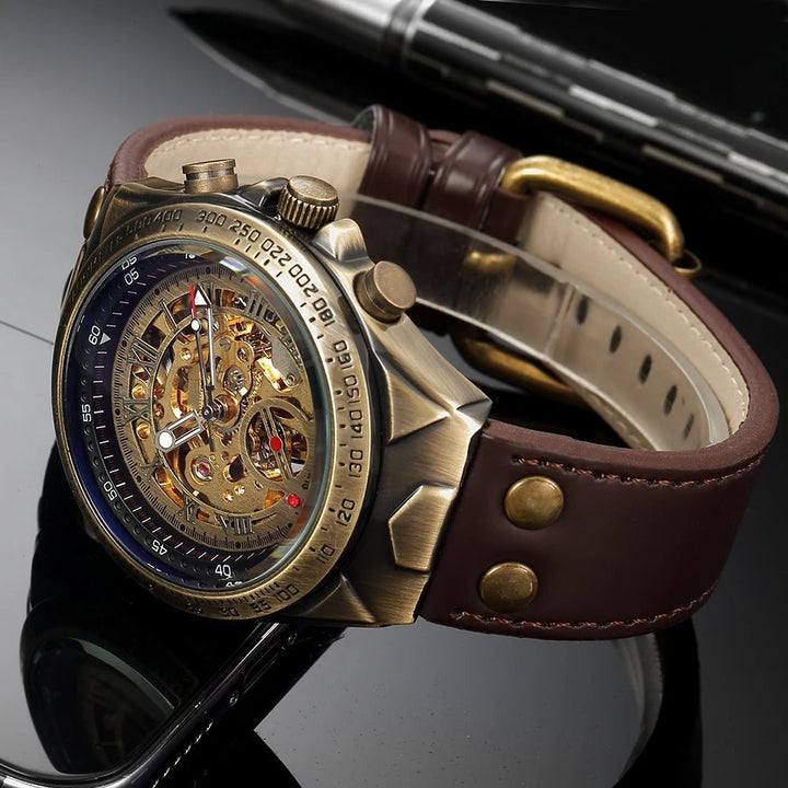 Vintage style men's skeleton watch with an open heart dial, antique gold case, and classic brown leather band.