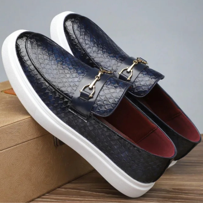 Top-down view of men's Aureo slip-on loafers, showcasing the full embossed snakeskin pattern & gold bar detail.