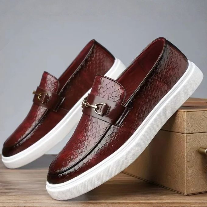 Detail shot of men's Aureo loafers, focusing on the embossed texture, gold accent, and comfortable design.