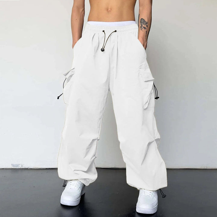 Men's baggy parachute cargo pants in a streetwear style, featuring a loose fit & utility pockets.
