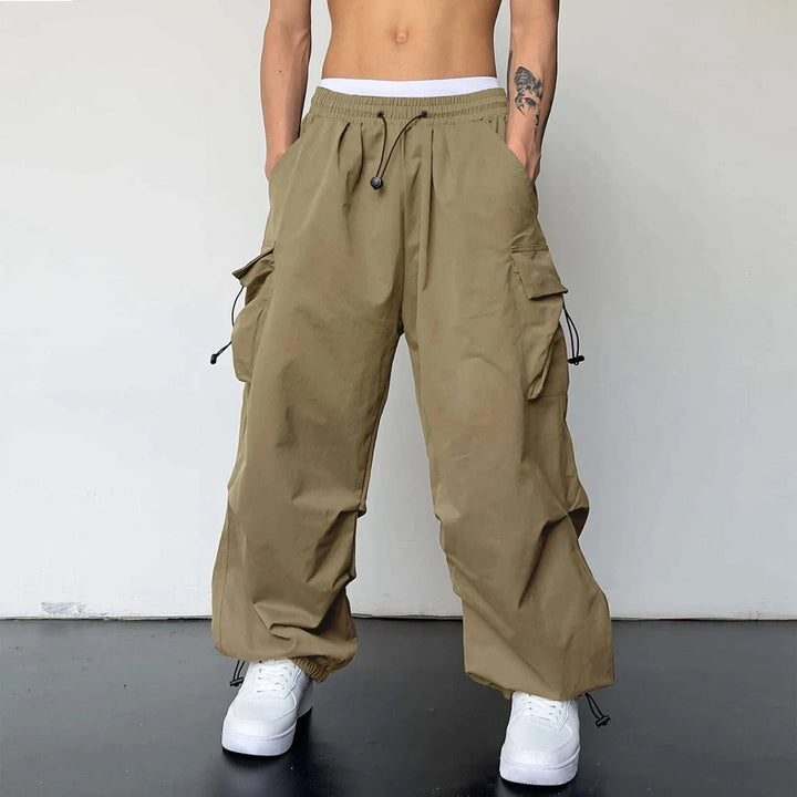 Modern men's loose fit parachute cargo pants, ideal for streetwear, with practical utility pockets.