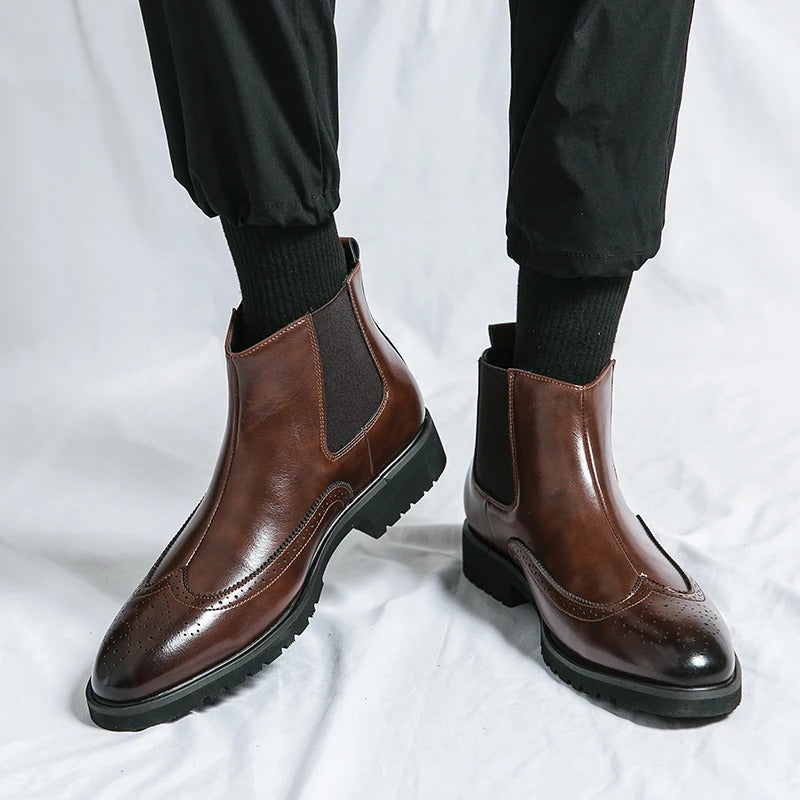 Men's black Chelsea boots, featuring a brogue design for a smart casual or dressy appearance.