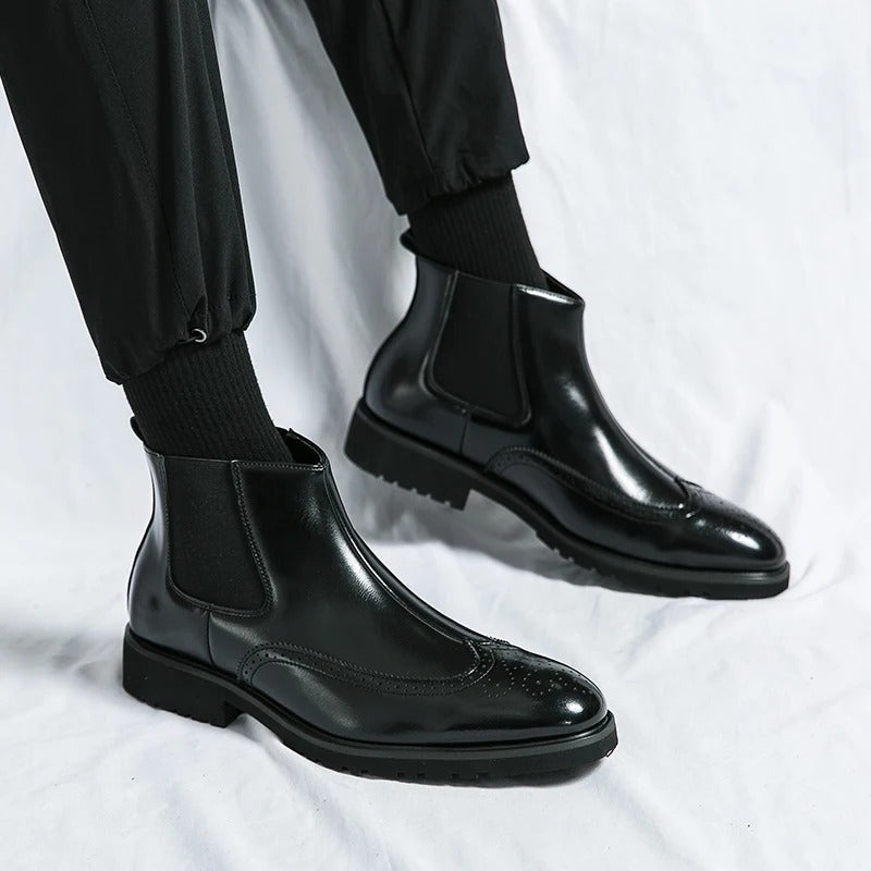Men's black Chelsea boots with brogue detailing, combining comfort and sophisticated style.