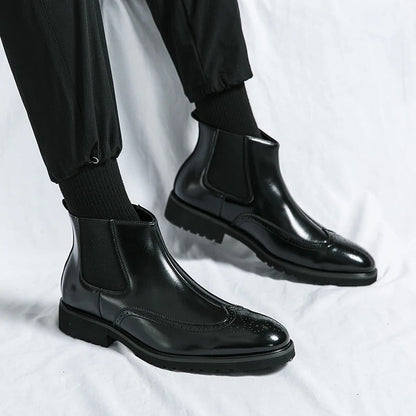 Men's black Chelsea boots with brogue detailing, combining comfort and sophisticated style.
