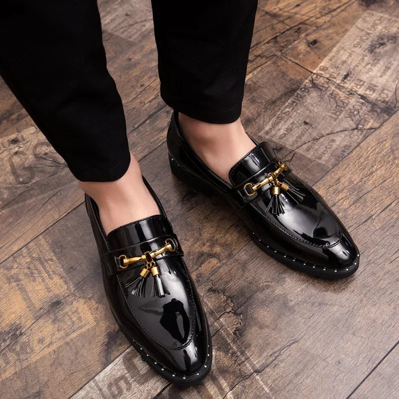 Shiny black patent leather men's loafers. Bold slip-on dress shoes with decorative tassels for formal wear.