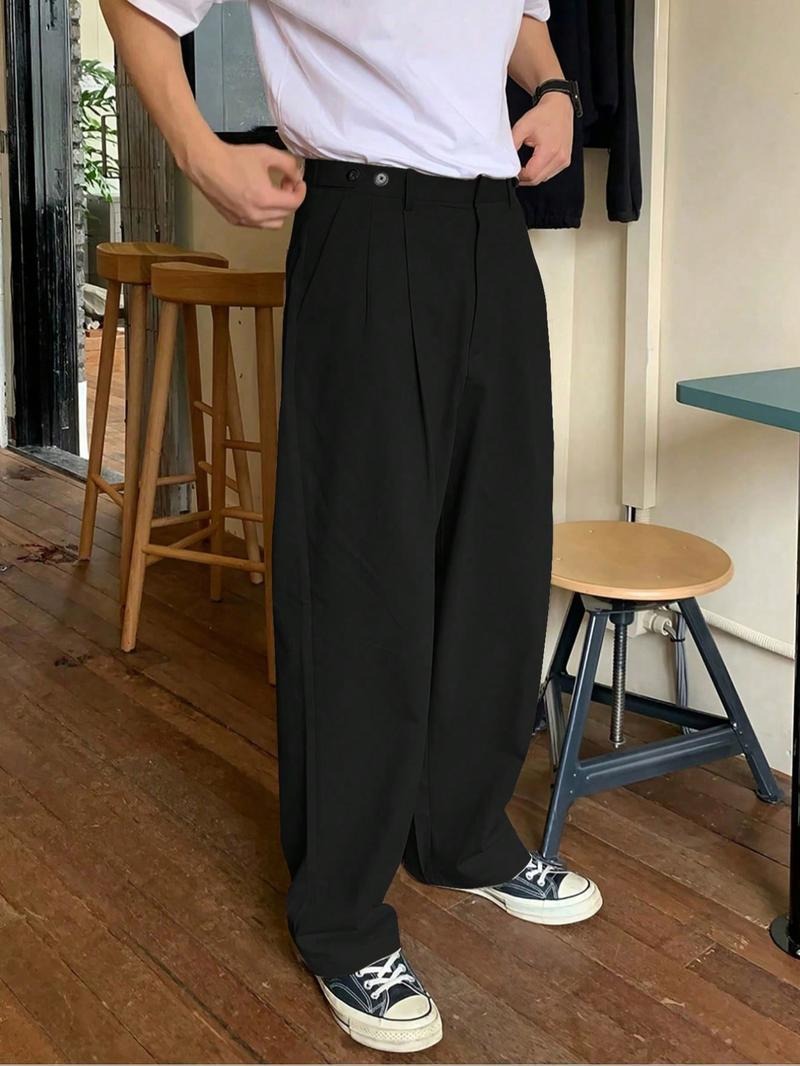 Effortlessly stylish men's wide-leg pleated trousers in black. Comfortable, modern tailored menswear pants.