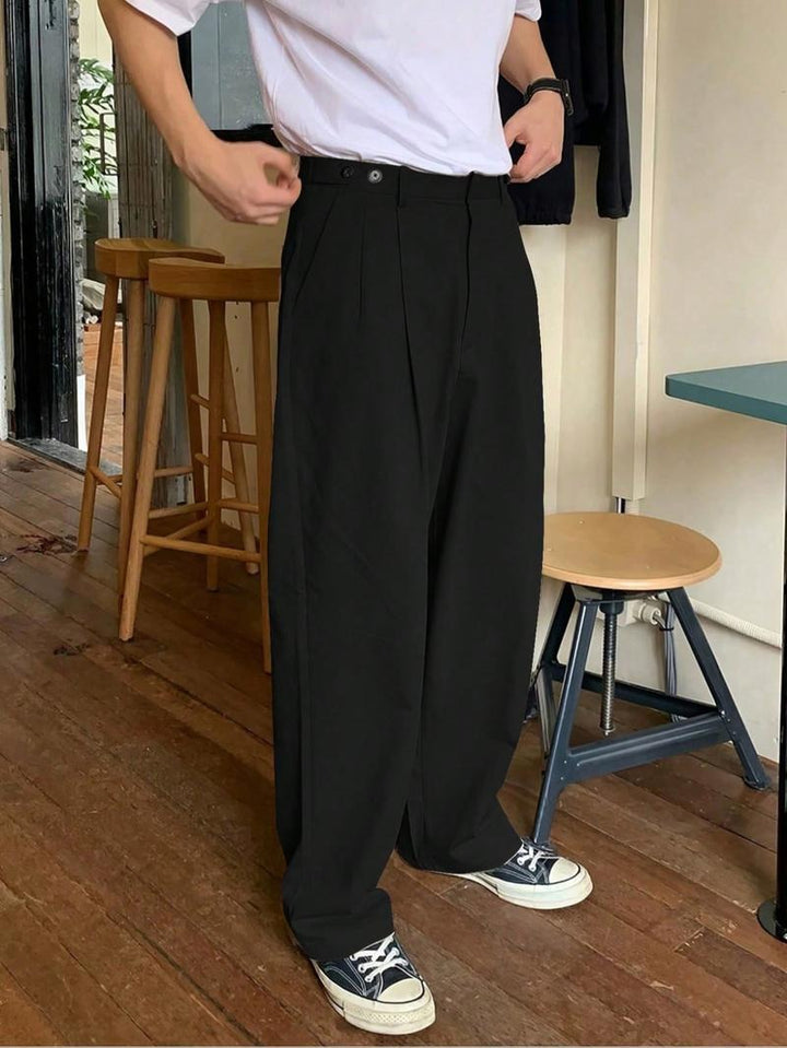 Effortlessly stylish men's wide-leg pleated trousers in black. Comfortable, modern tailored menswear pants.