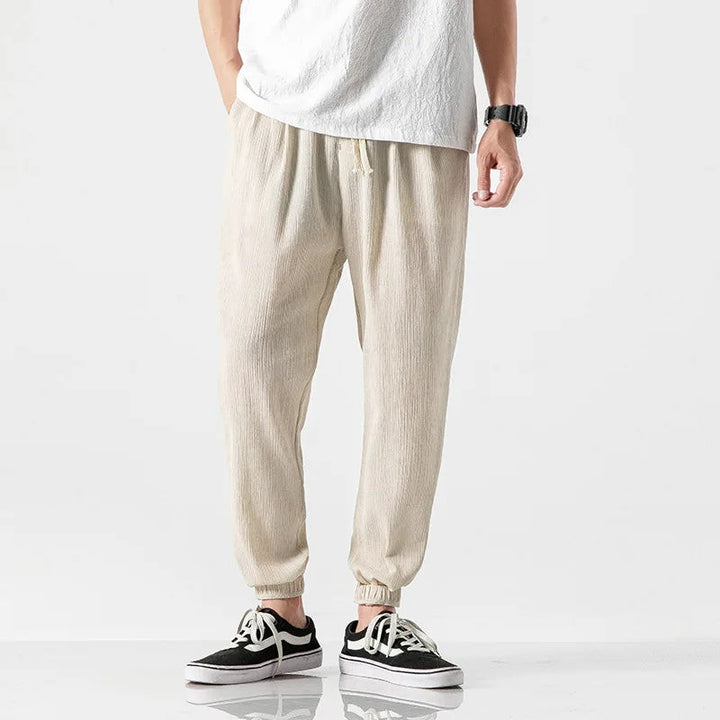 Close-up of elastic waist & drawstring on men's relaxed fit tapered joggers for secure comfort.