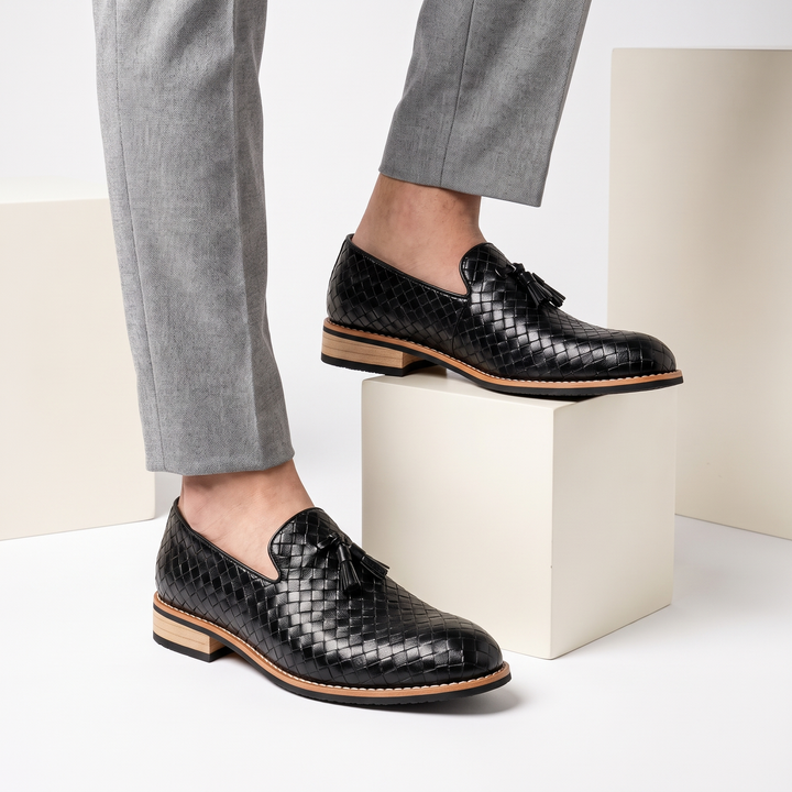 Close-up of men's pointed toe tassel loafers, showcasing the luxurious leather and slip-on design of these dress shoes.