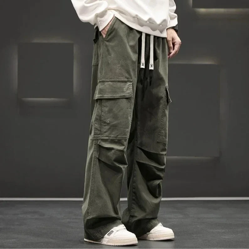 Man wearing relaxed fit utility cargo pants, walking outdoors, showcasing functional design and freedom of movement.