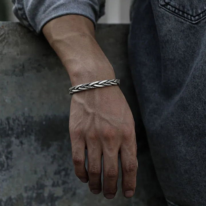 Close-up of a men's sterling silver braided cuff bracelet. Detailed craftsmanship, adjustable fit for men.