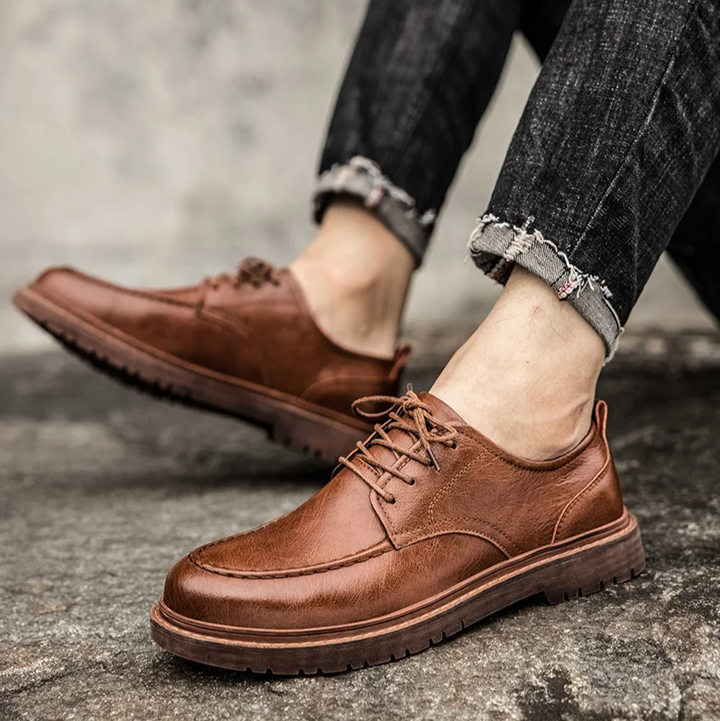 Stylish men's brown leather lace-up Derby shoes. Versatile classic footwear for formal events or casual outings.