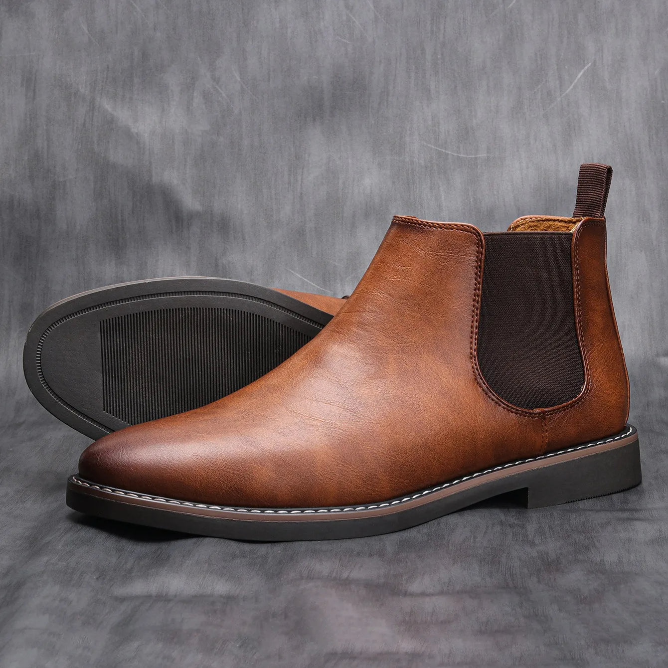 Stylish men's black leather Chelsea boots, perfect for casual outfits, worn with dark jeans.