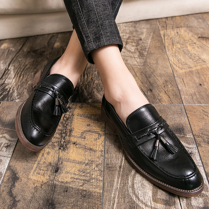 Polished black men's dress loafers with tassels, enhancing any elegant fashion statement.