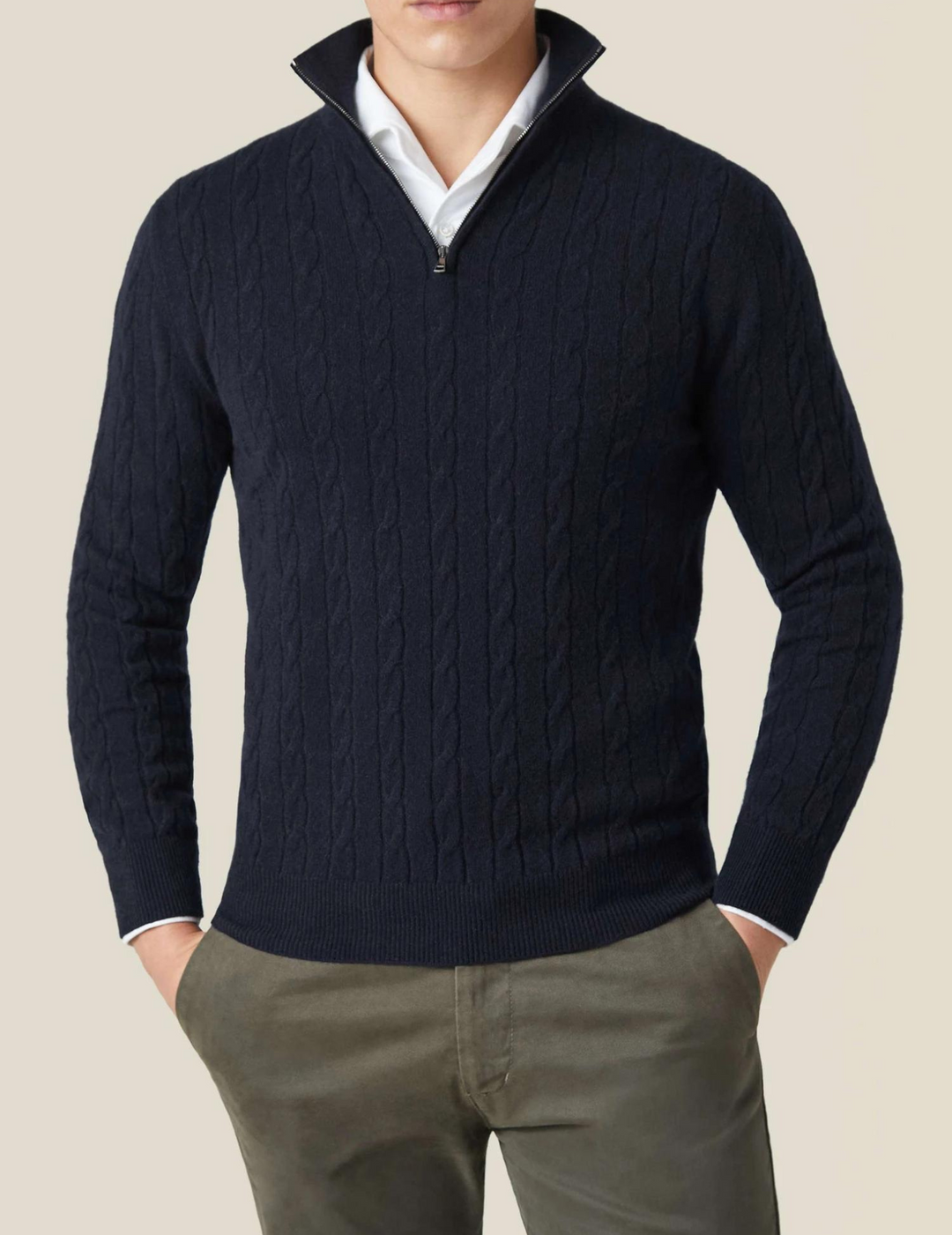 Close-up of a men's cable knit sweater, showing the intricate textured knit pattern and quarter zip.