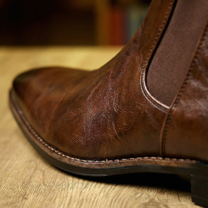 Dark brown full-grain leather men's Chelsea boots, durable slip-on footwear built for style and comfort.