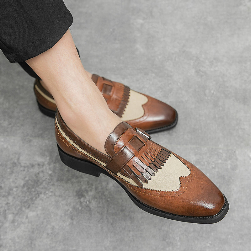 Close-up of a men's classic brogue loafer, showcasing the intricate wingtip and fringe.