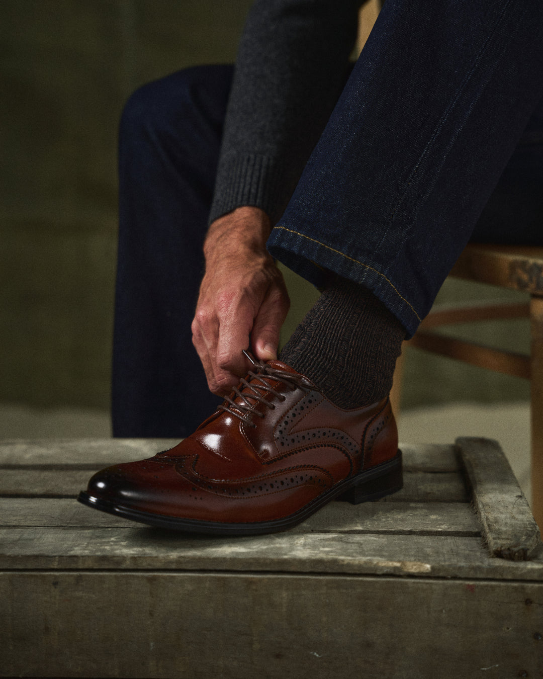 Close-up of premium leather texture on men's classic Oxford brogues, highlighting quality dress shoes.