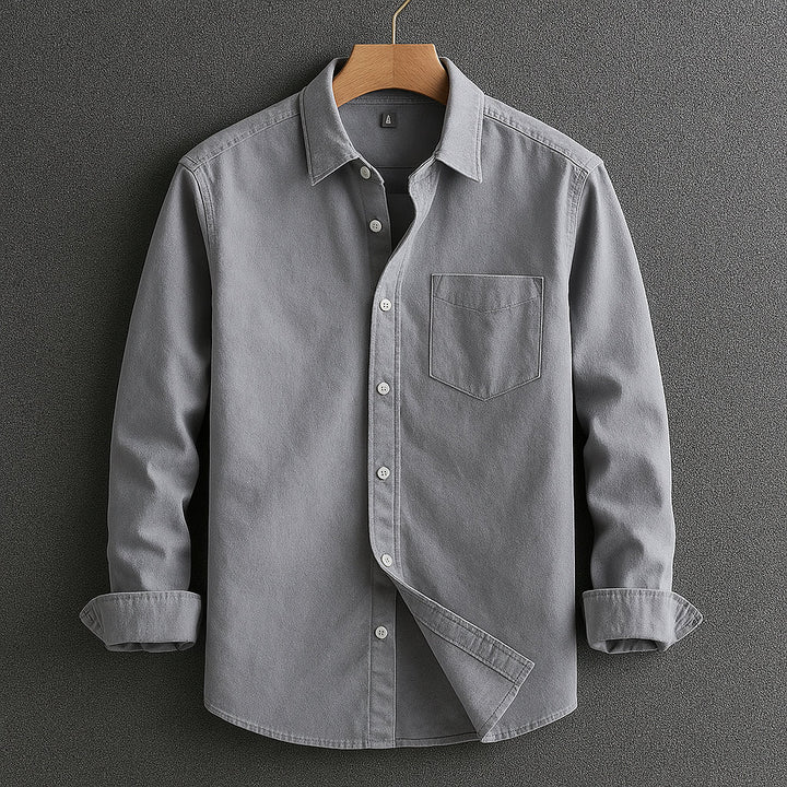 Man wearing a blue Oxford shirt, a comfortable long-sleeve style perfect for smart casual occasions.