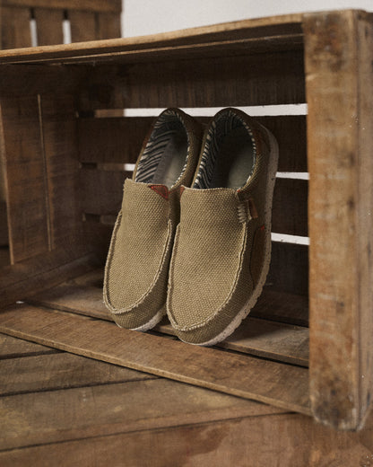 Khaki canvas slip-on shoes for men, featuring a comfortable design and sturdy rubber sole for casual use.