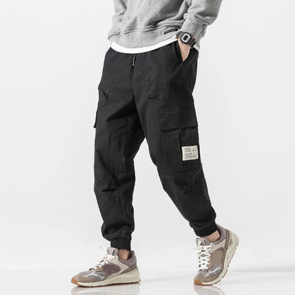 Man wearing comfortable tapered joggers, demonstrating the casual fit and soft cotton blend for active or lounge use.
