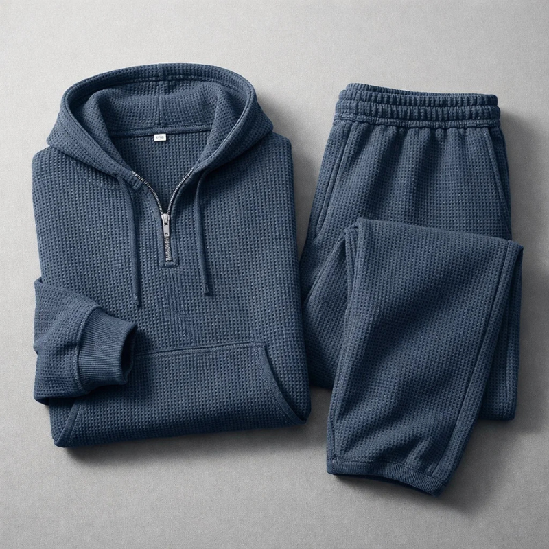Man lounging in a blue men's textured athleisure set, featuring a soft hoodie & matching joggers.