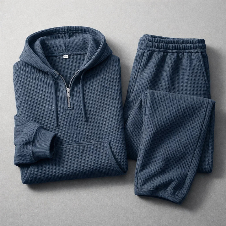 Man lounging in a blue men's textured athleisure set, featuring a soft hoodie & matching joggers.