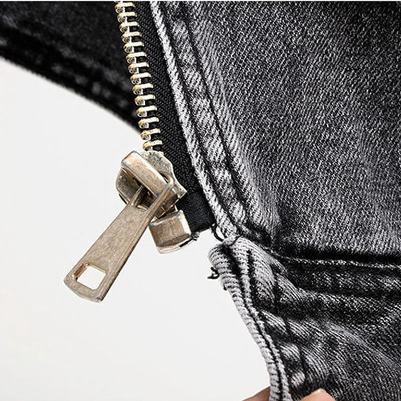 Fashionable men's moto vest in distressed black denim, featuring an asymmetric zip and a belted waist.