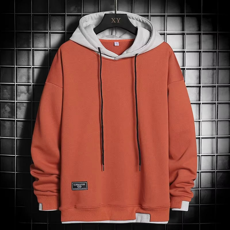 Modern men's dual-tone pullover hoodie with a trendy layered hem, blending comfort with streetwear apparel.