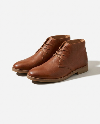 Detailed view of strong laces & eyelets on men's durable brown leather chukka boots, built for long-lasting wear.