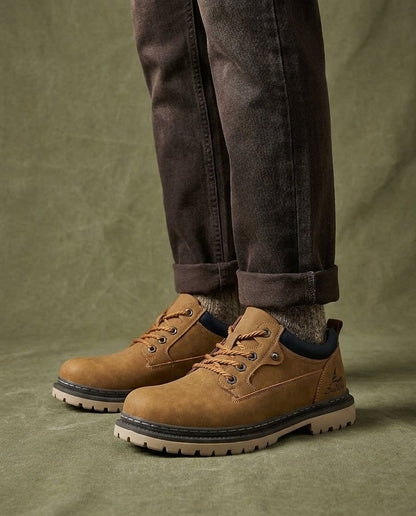 Close-up of rugged men's brown leather work boot, showcasing durable stitching and texture.