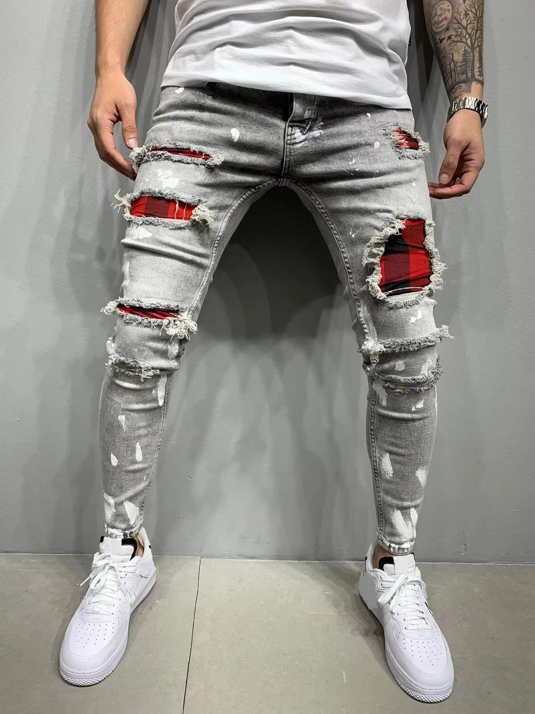 Casual men's distressed denim jeans, featuring an edgy style and comfortable tapered fit for everyday wear.