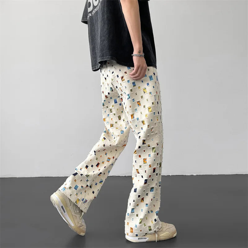 Close-up of men's casual pants showing detailed rips and creative patchwork for modern fashion.