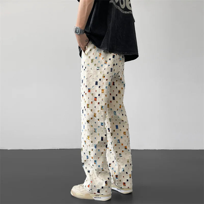 Stylish men's streetwear pants featuring a unique ripped and patchwork design, great for casual wear.