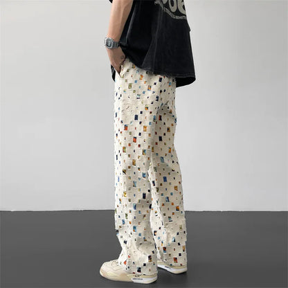 Stylish men's streetwear pants featuring a unique ripped and patchwork design, great for casual wear.