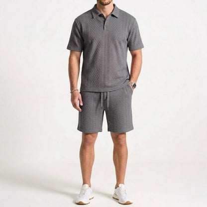 Man modeling a comfortable men's polo and shorts two-piece set. Ideal for effortless summer casual wear.