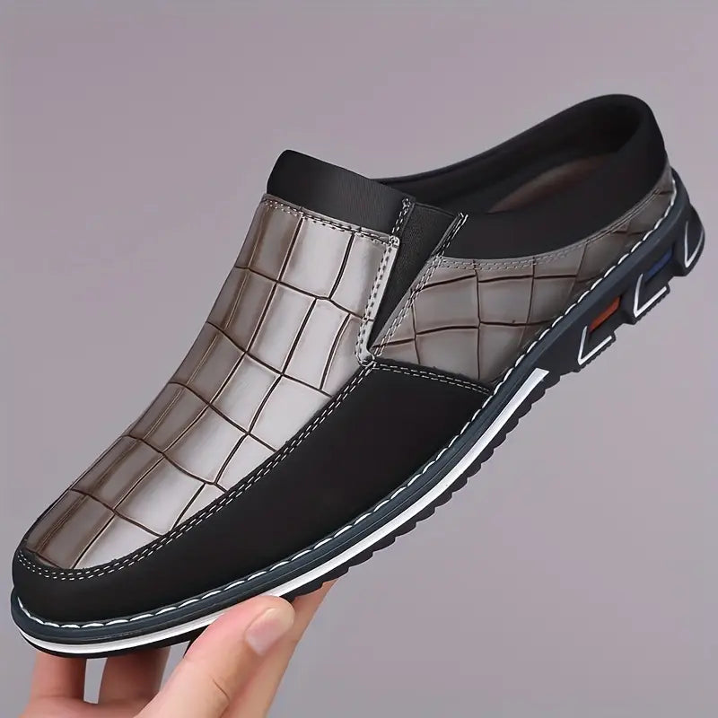 Close-up of sophisticated embossed texture on men's elegant slip-on mules.