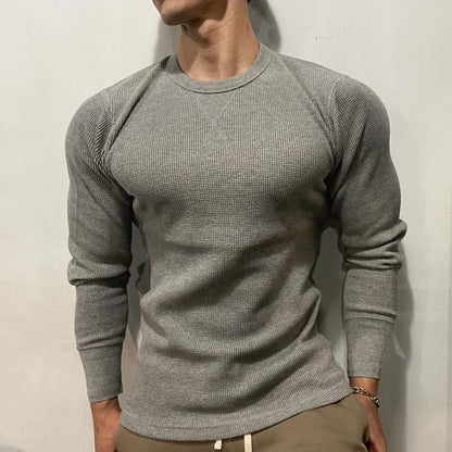 Back view of a man wearing a black fitted muscle shirt, highlighting the athletic physique & gym wear.