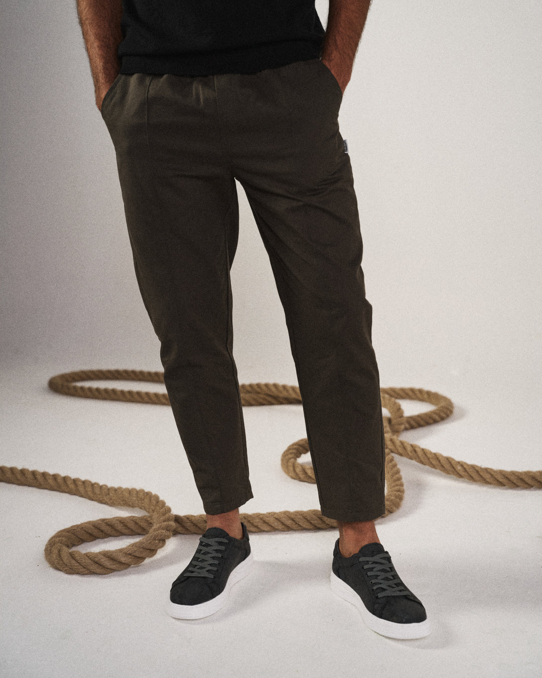Stylish men's black tapered joggers on model, perfect for modern casual wear, athleisure, & relaxed fit.