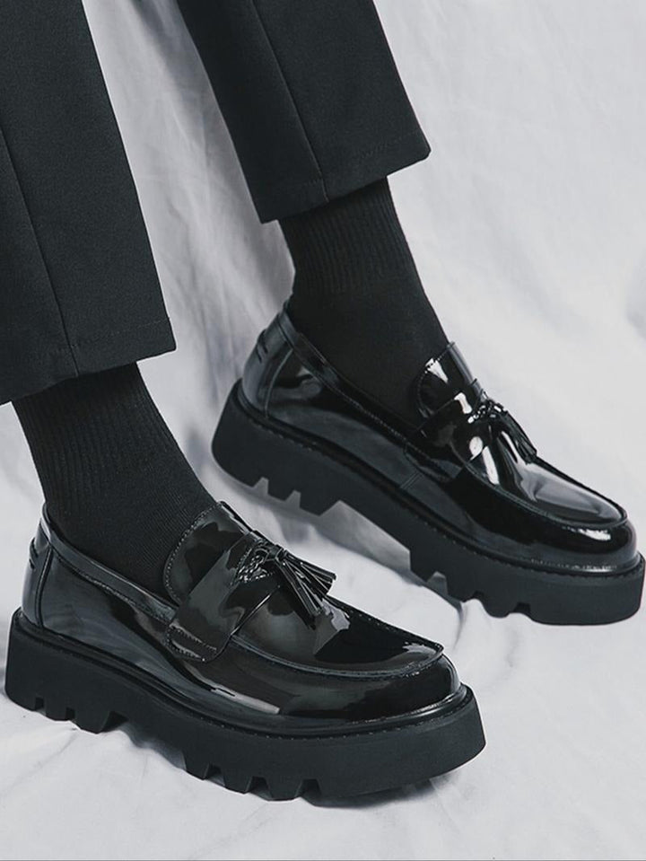 Men's high-shine black tassel loafers with a modern chunky sole, perfect for formal wear & polished look.