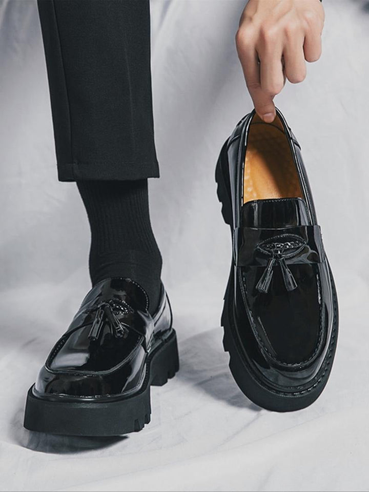 Stylish men's black tassel slip-on loafers with a chunky sole, offering comfort and modern formal wear.