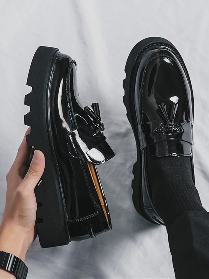 Men's high-shine black slip-on tassel loafers. Modern chunky sole for comfortable, polished formal dress shoes.