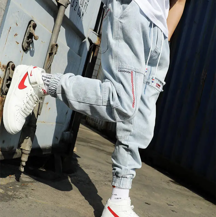 Men's Jacques Tapered Denim Joggers paired with sneakers, highlighting modern look & casual style.