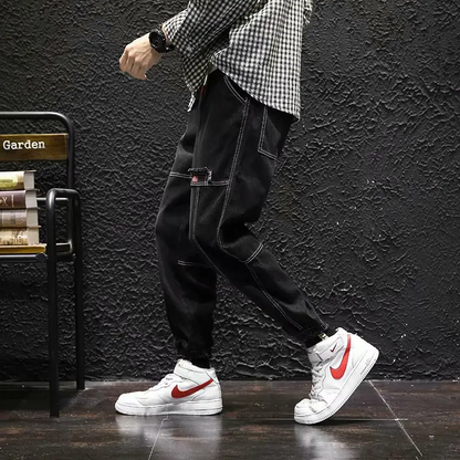 Man wearing versatile Jacques Tapered Denim Joggers, ideal for casual, modern looks & comfort.