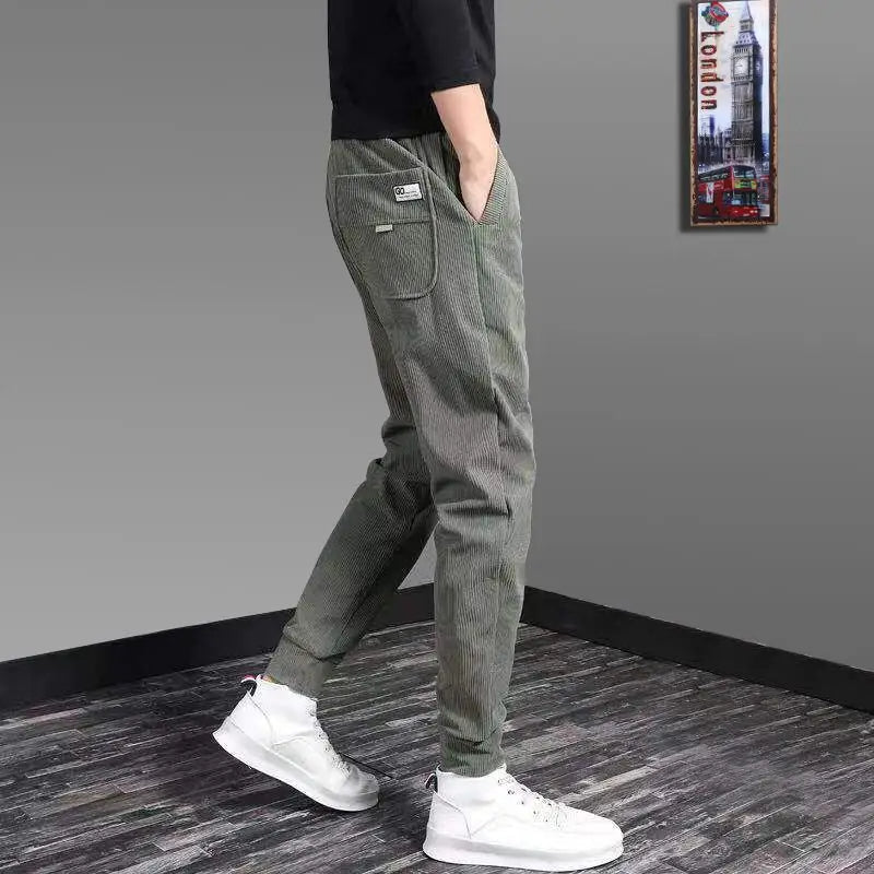 Man lounging comfortably in Men's Kaizen Jogger Pants. Relaxed fit, soft fabric ideal for casual wear at home.